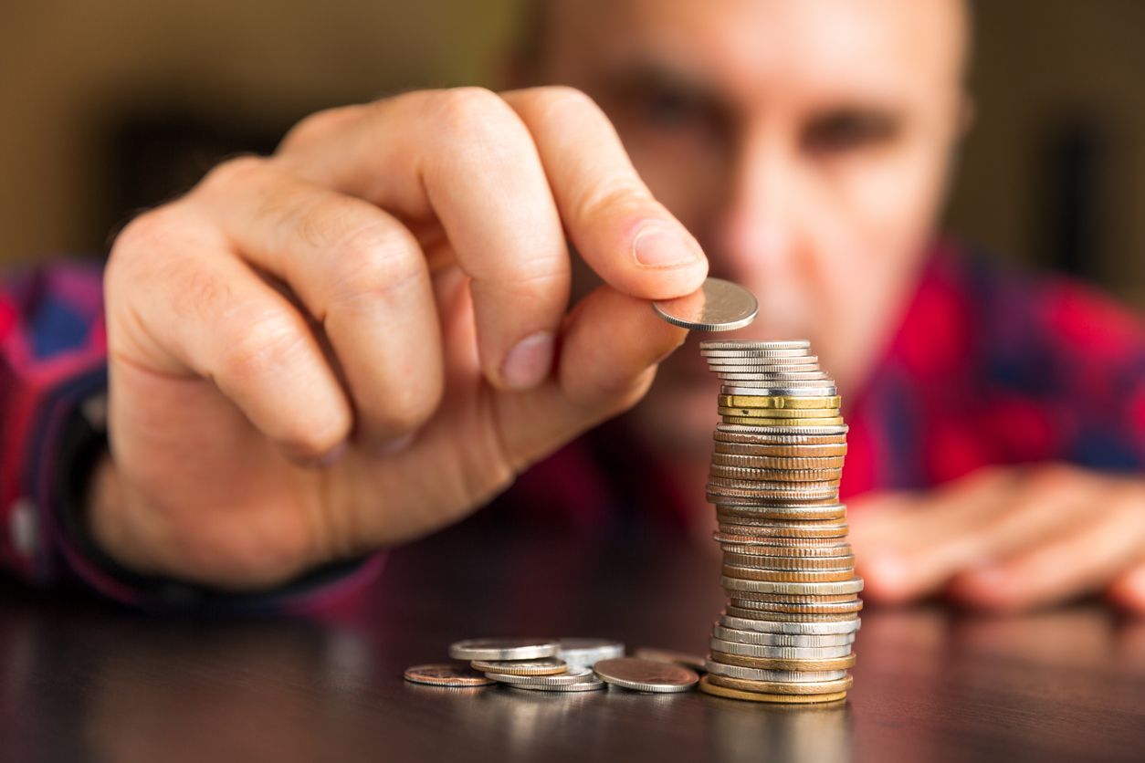 Man counts his coins on a table. Cashless laundry in Nashville means no more saving quarters for laundromats