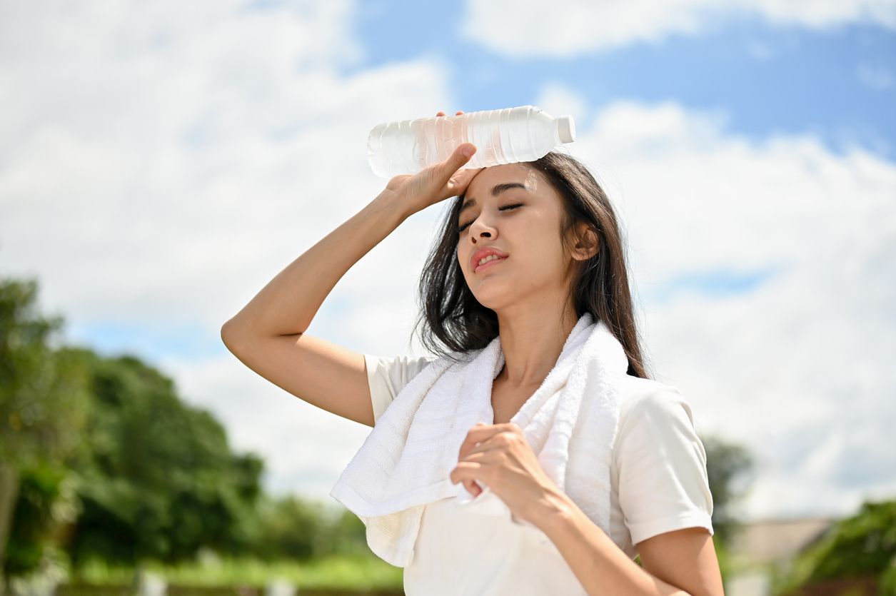 Woman in humid Nashville summer heat wiping her forehead – humidity and laundry challenges