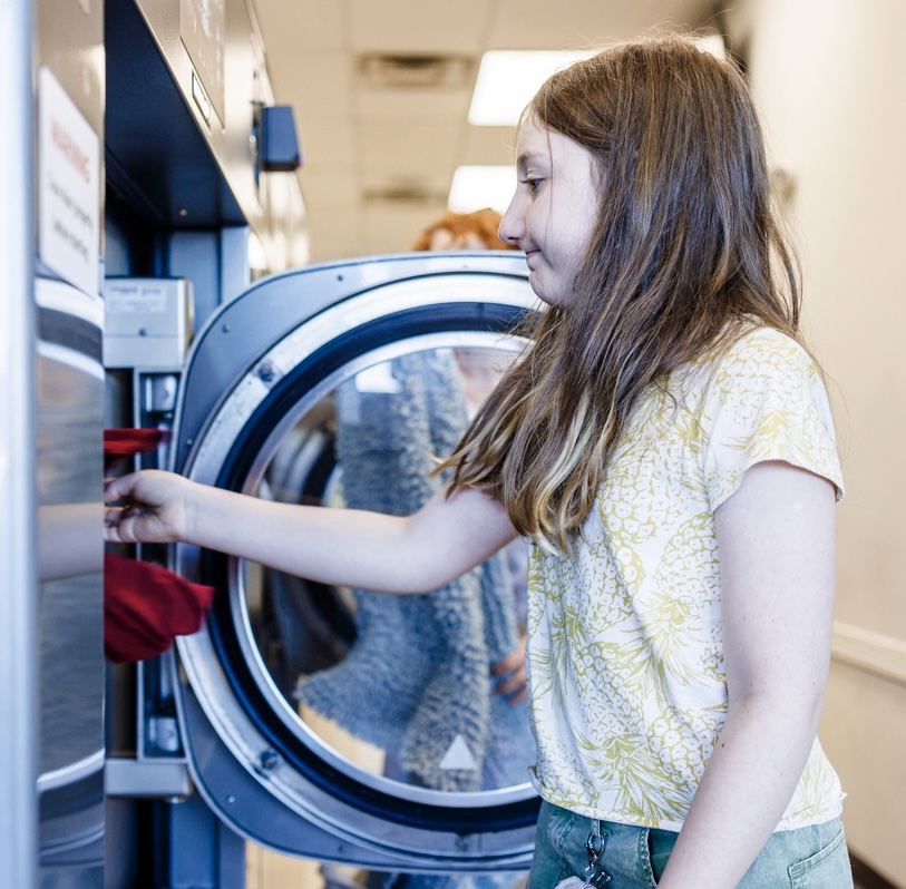 Child doing laundry at kid-friendly laundromat in Nashville